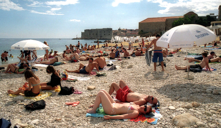 Sun bathers relax on the pebbled beach outside Dubrovnik, Croatia. With the Cruising Croatia and Adriatic Islands Package, you get round-trip airfare, three nights' hotel accommodations, seven nights aboard a small ship, meals, land transportation, and shore excursions, from $2,295 per person.