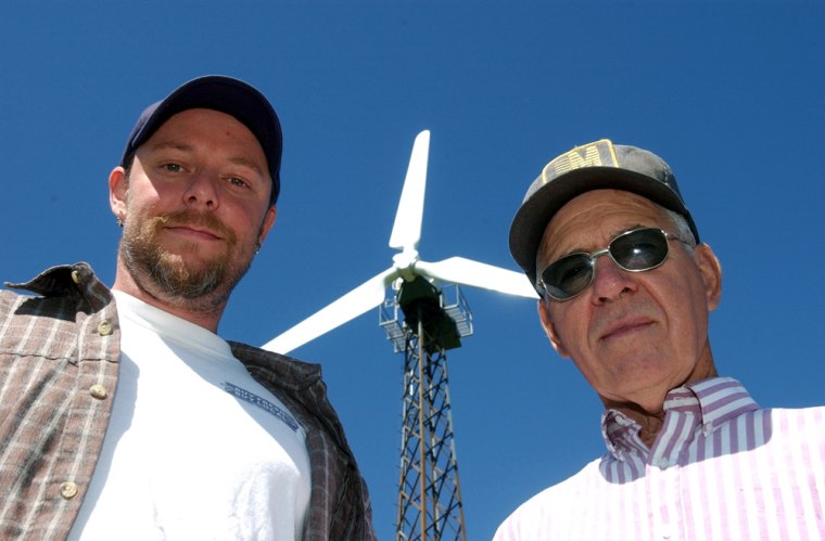 Brain Zachary and his father-in-law, Joseph Weishaar, stand in front of the electric wind turbine they erected on their farm just outside of Creston, Iowa. 