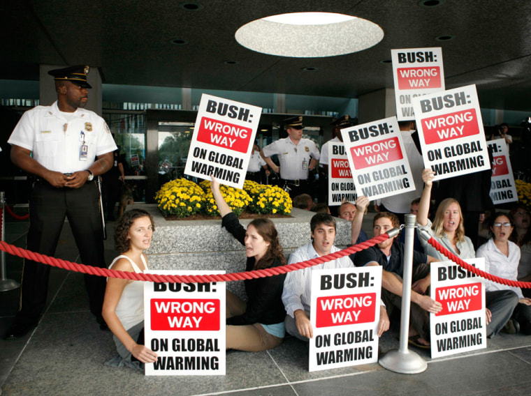 Protesters hold signs during a demonstration at the Major Economies Meeting on Energy Security and Climate Change at the State Department in Washington