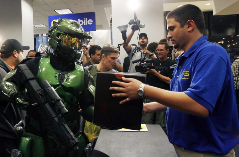 Dressed as the character Master Chief from the Xbox 360 video game \"Halo 3\", gaming fan Jim Cush purchases his copy of the game during a midnight sales event in New York