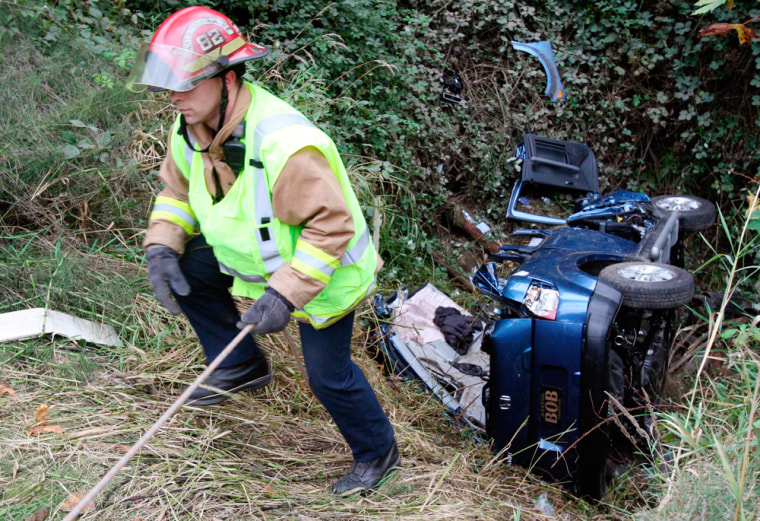 A firefighter on Thursday pulls himself up from a steep ravine where Tanya Rider was found inside her crashed vehicle.