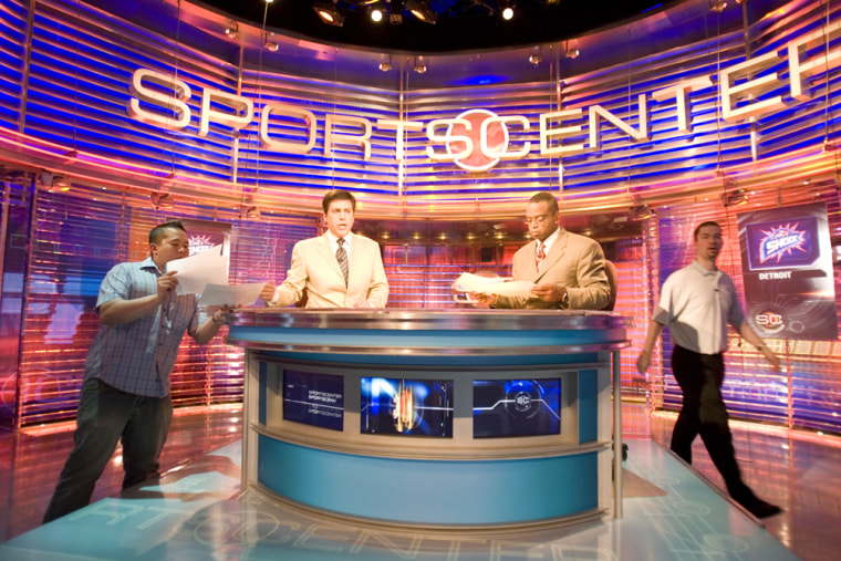 Four men work behind the backdrop inside the Sportscenter TV