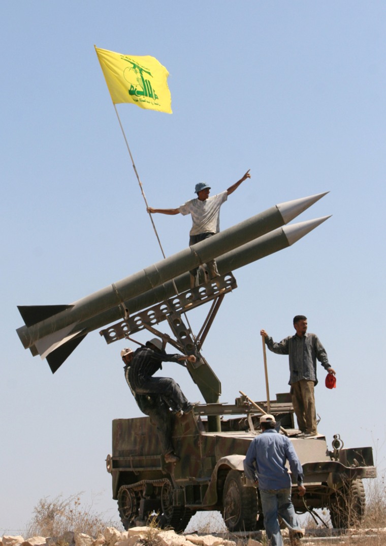Hezbollah supporters, who have seemingly grown in number since the 2006 war with Israel, fix their party's flag on top of their rocket near the southern port city of Tyre, Lebanon.