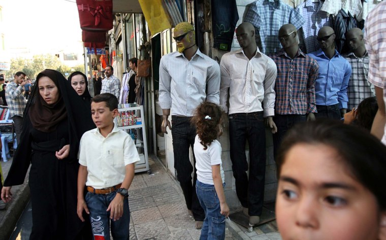 Iranian women with Islamic veils walk past mannequins in an open market in Tehran on Sept. 16.