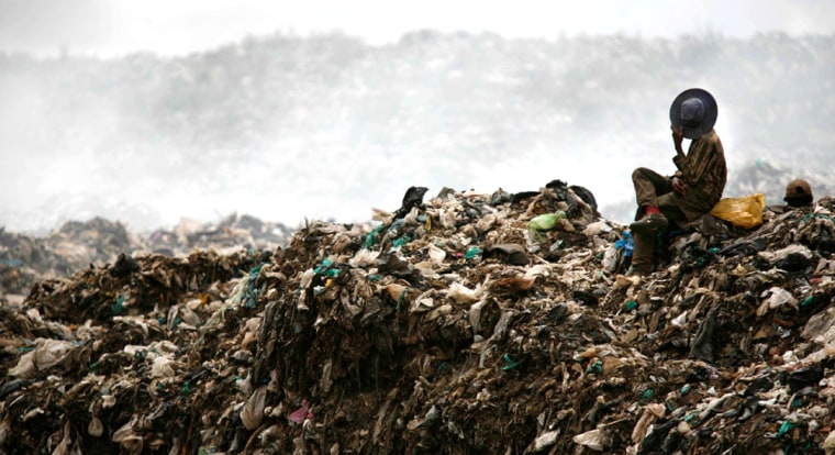 A scavenger covers his face at Dandora rubbish dump in Nairobi