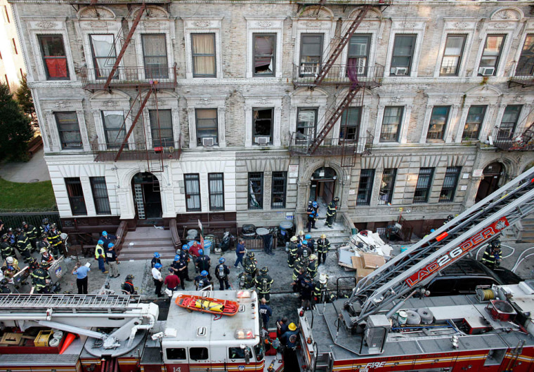 Firefighters, police and rescue personnel work at the scene of an explosion on 119th street in the Harlem neighborhood of New York