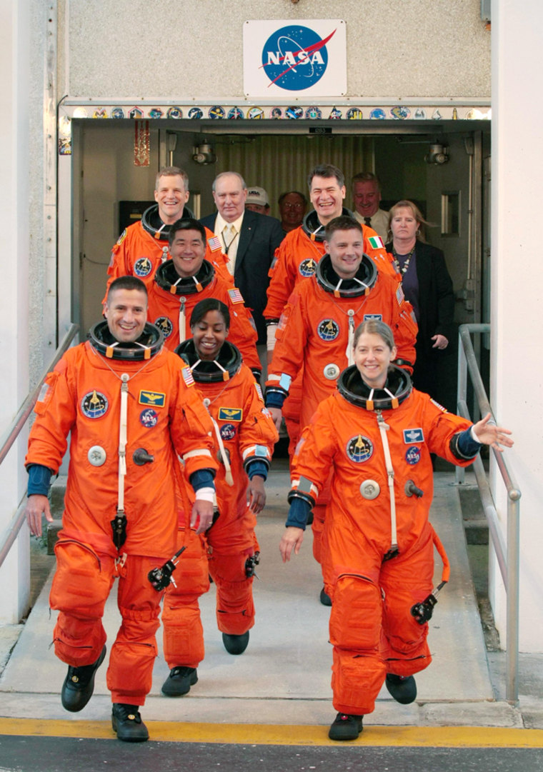 The crew of the shuttle Discovery's next mission walks out for a dress rehearsal of the launch countdown Wednesday. In the left row, from front, are pilot George Zamka, Stephanie Wilson, Daniel Tani and Scott Parazynski. In the right row, from front, are mission commander Pam Melroy,  Doug Wheelock and Paolo Nespoli.