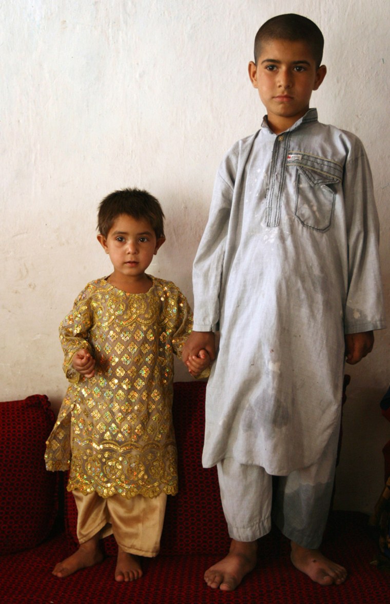 Three-year-old Sunam, wears her engagement outfit and holds hands with her fiance, her 7-year-old cousin, Nieem, in Kabul, Afghanistan, July 11, 2007. Sunam cannot talk yet, but Parvez agreed to engage his young daughter because his sister, Fahima, Nieem's mother, did not have a daughter and desperately wanted one. (AP Photo/Farzana wahidy)