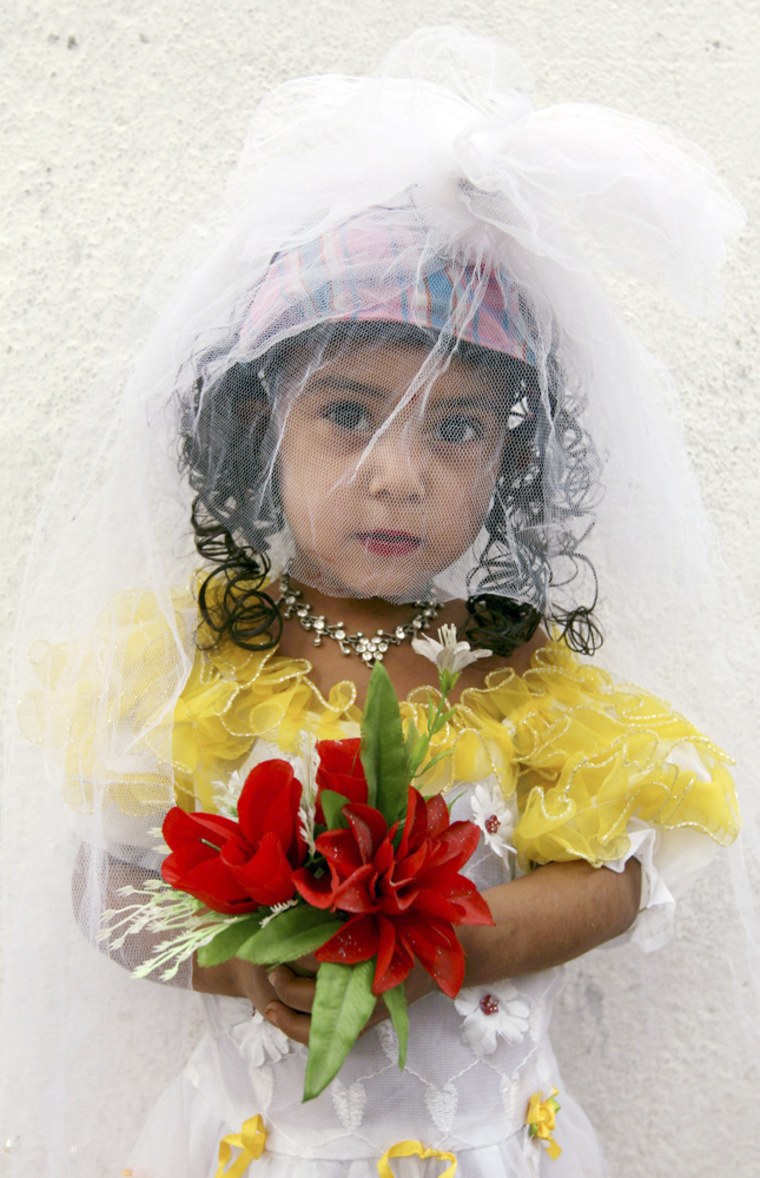 Three-year-old Sunam wears a bridal outfit in Kabul, Afghanistan, in August. She is arranged to be married to her 7-year-old cousin.