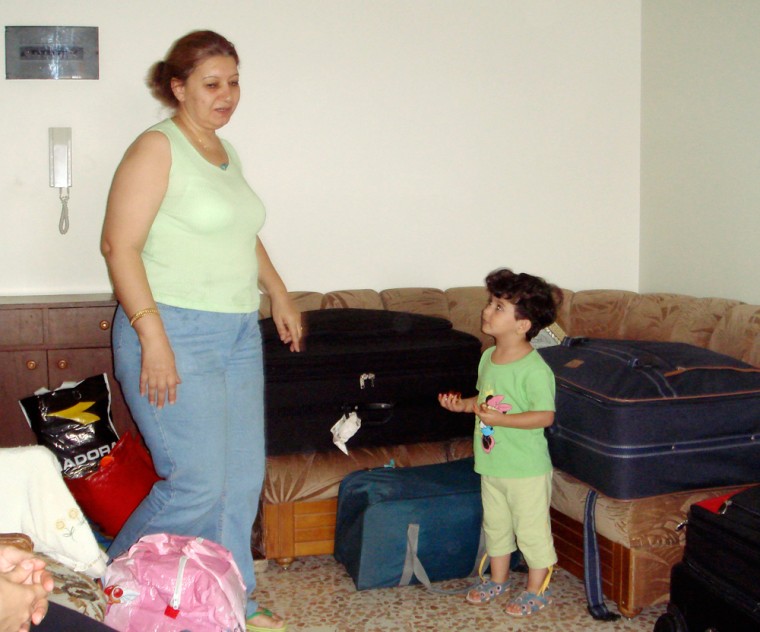 Iraqi refugees Iman Faleh, left, and her granddaughter Rania, 3, pack suitcases in their Syrian house on Aug. 21 as they prepare to return to Iraq.