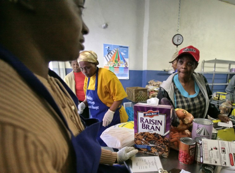 Food pantries, which distribute food to the needy, can't keep up with all the mouths they have to feed — and the government has cut funding. On the far left, a volunteer at the Bedstuy Campaign Against Hunger, Marcia Watkis, checks groceries for Merna Smith, right, in the Brooklyn borough of New York.