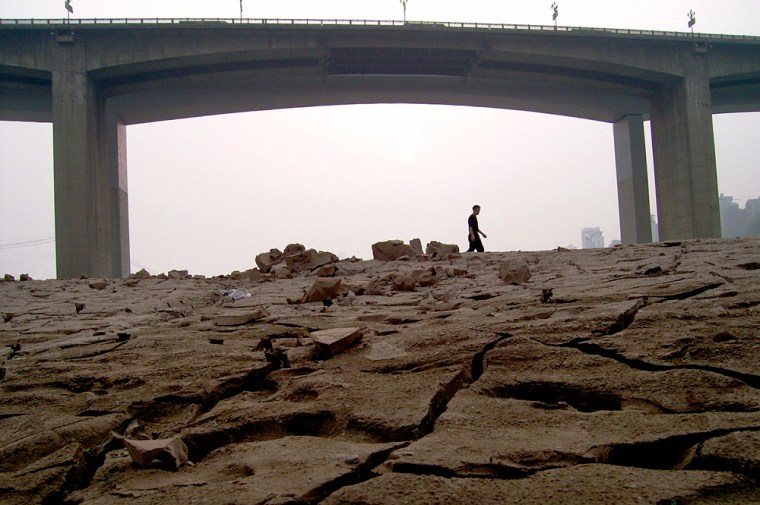 A local resident walks on the dried-up riverbed of Yangtze River, southwestern China's Chongqing municipality