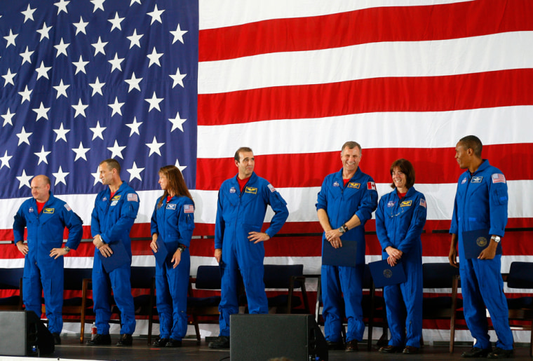 Space shuttle Endeavour astronauts stand in front of a large U.S. flag after their return to Houston, Wednesday, Aug. 22, 2007. The crew, from left: Commander Scott Kelly, Pilot Charles Hobaugh, Mission Specialists Tracy Caldwell, Richard Mastracchio, Dave Williams (from the Canadian Space Agency), Barbara R. Morgan and Alvin Drew. 