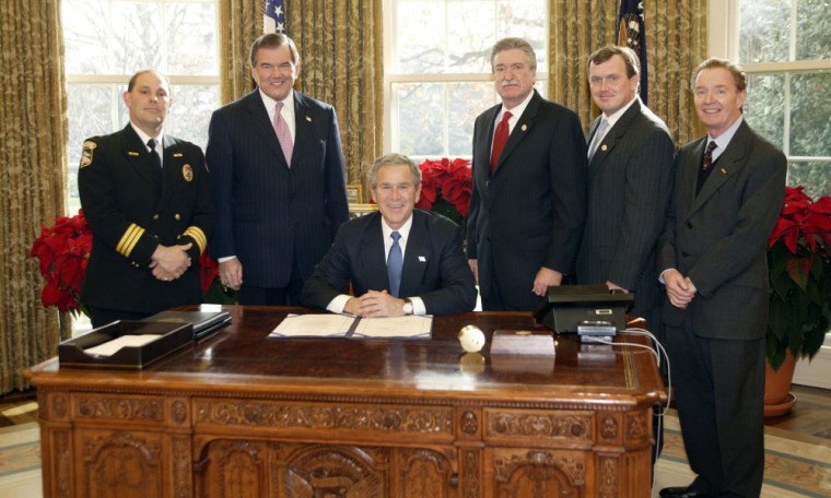 President Bush at the signing of the Hometown Heroes Act on Dec. 15, 2003. Both the president and Vice President Cheney have cited their support for the law. But so far, no families have been paid.