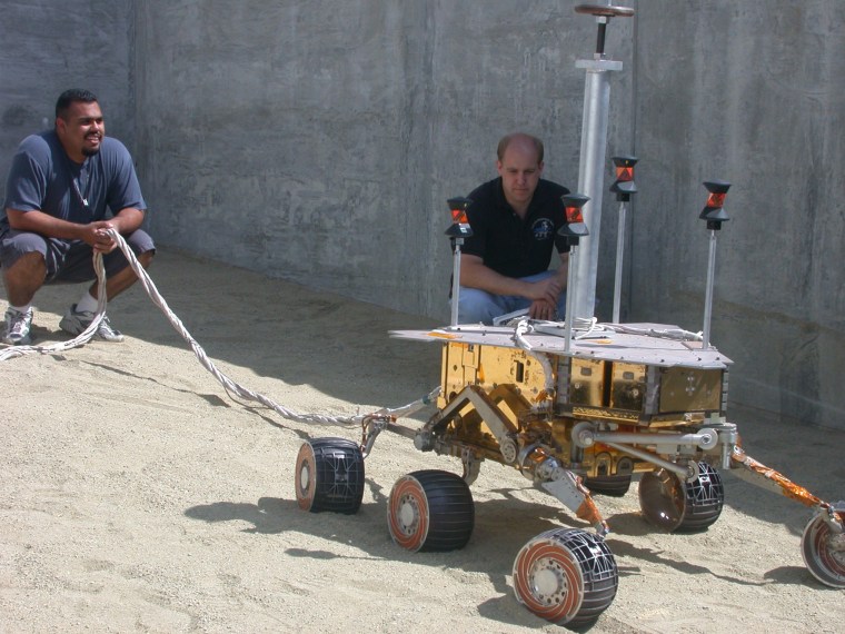 JPL engineers Eric Aguilar, left, and Joe Melko monitor the rover's performance on a sandy slope outside JPL's In-Situ Instrument Lab.