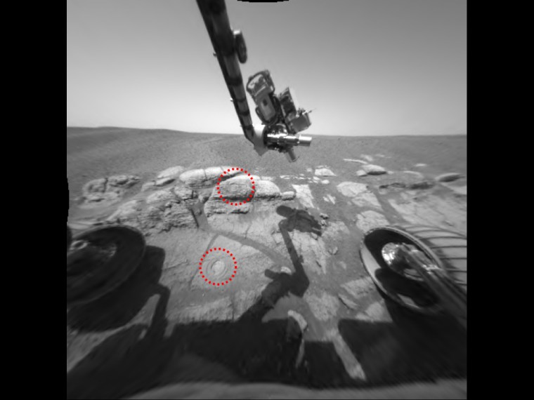 This image taken by the Mars Exploration Rover Opportunity shows the two holes that allowed scientists to peer into Meridiani Planum's wet past. The rover drilled the holes into rocks in the region dubbed \"El Capitan\" with its rock abrasion tool. By analyzing the freshly exposed rock with the rover's suite of scientific instruments, scientists gathered evidence that this part of Mars may have once been drenched in water. The lower hole, located on a target called \"McKittrick,\" was made on the 30th martian day, or sol, of Opportunity's journey. The upper hole, located on a target called \"Guadalupe\" was made on the 34th sol of the rover's mission. This image was taken on the 35th martian day, or sol, by the rover's hazard-avoidance camera. The rock abrasion tool and scientific instruments are located on the rover's robotic arm.