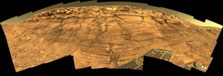 NASA's Mars Exploration Rover Opportunity captured this view of \"Burns Cliff\" after driving right to the base of this southeastern portion of the inner wall of \"Endurance Crater.\" The view combines frames taken by Opportunity's panoramic camera between the rover's 287th and 294th martian days (Nov. 13 to 20, 2004). This is a composite of 46 different images, each acquired in seven different Pancam filters. It is an approximately true-color rendering generated from the panoramic camera's 750-nanometer, 530-nanometer and 430-nanometer filters. The mosaic spans more than 180 degrees side to side. Because of this wide-angle view, the cliff walls appear to bulge out toward the camera. In reality the walls form a gently curving, continuous surface.