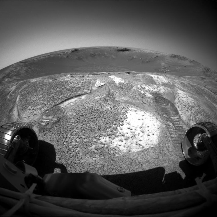 NASA's Mars Exploration Rover Opportunity climbed out of \"Endurance Crater\" during the rover's 315th sol (Dec. 12, 2004), and used its front hazard-avoidance camera to look back across the crater from the rim. The rover spent just over six months inside the stadium-sized crater, examining in detail the tallest stack of bedrock layers ever seen up close on a foreign planet.