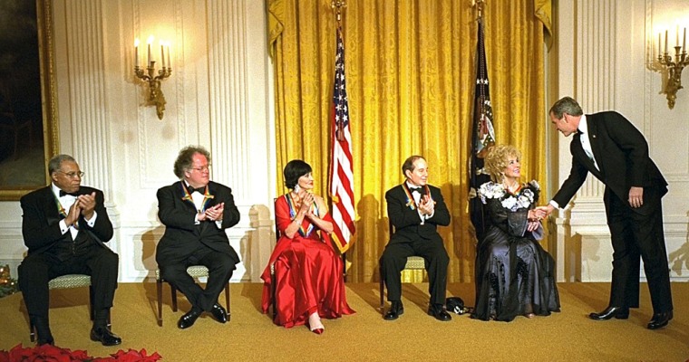This photo released by The White House 08 December, 2002, shows US President George W. Bush (R) shaking hands with Kennedy Center honoree actress Elizabeth Taylor 08 December at The White House in Washington DC. Bush met with the honorees (L-R) actor James Earl Jones, music conductor James Levine, dancer-actress Chita Rivera, singer-songwriter Paul Simon and Taylor. AFP PHOTO/THE WHITE HOUSE/ERIC DRAPER