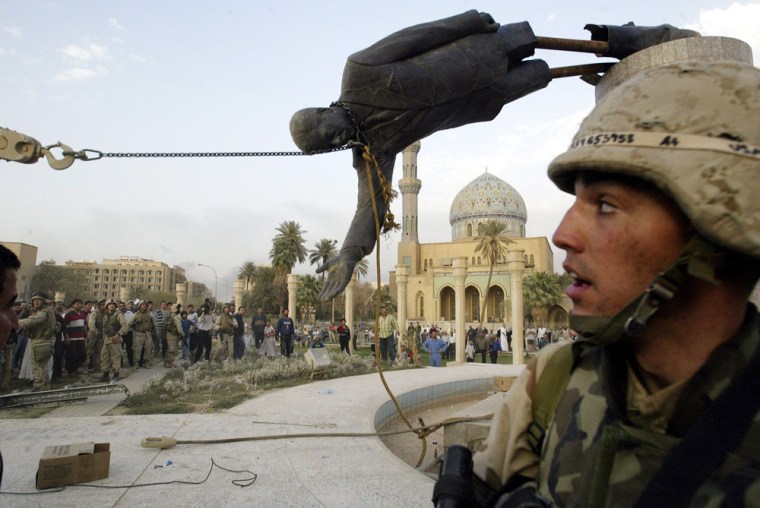 **FILE** Iraqi civilians and U.S. soldiers pull down a statue of Saddam Hussein in downtown Baghdad in this April 9, 2003, file photo. (AP Photo/Jerome Delay, File)