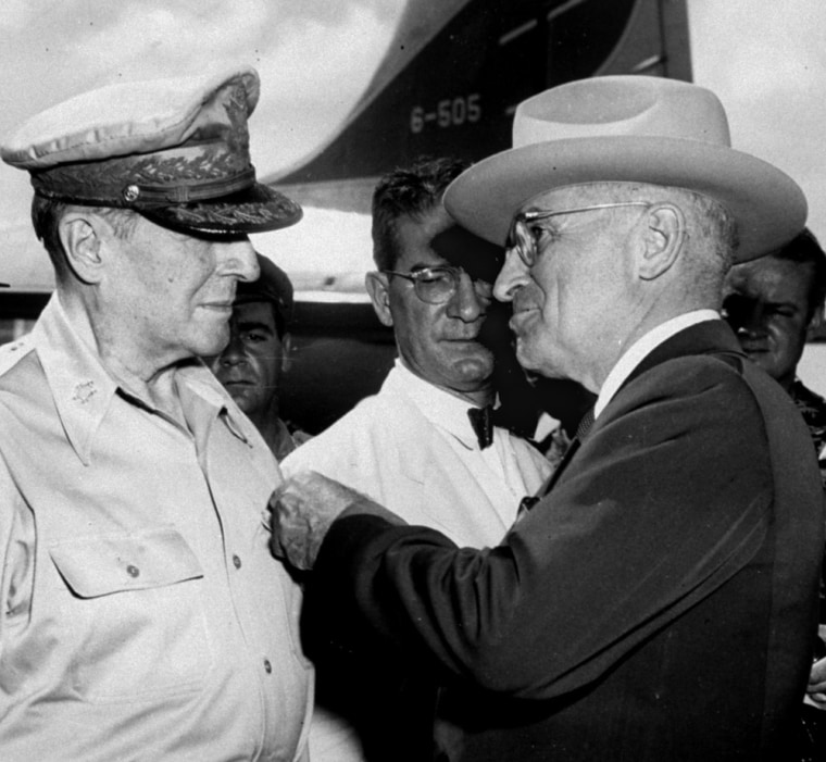 **FILE** President Truman pins the Distinguished Service Medal with four oak leaf clusters on the shirt of General Douglas MacArthur during a ceremony at the airstrip on Wake Island, in this Oct. 14, 1950, file photo.  In the center is John J. Muccio, United States ambassador to Korea, who was decorated with a Medal of Merit. According to a letter sent by Muccio to the State Department, U.S. soldiers would fire on refugees if they approached U.S. lines. The letter referred to a policy set down on July 25, 1950, the night before members of the 7th U.S. Cavalry began killing South Korean refugees at the village of No Gun Ri. (AP Photo, File)