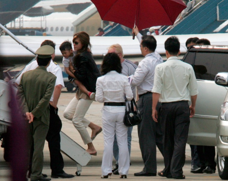 U.S. actress Jolie carries her newly adopted son as she walks from the car to the plane at Noi Bai airport in Hanoi