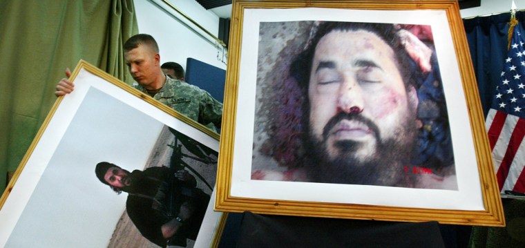 A U.S. soldier at a press conference in Baghdad, Iraq, takes down an older image, to display the latest image purporting to show the body of Abu Musab al-Zarqawi, the al-Qaida-linked militant who led a bloody campaign of suicide bombings, kidnappings and hostage beheadings in Iraq, who was killed Wednesday in a U.S. airstrike, Iraq's Prime Minister Nouri al-Maliki announced Thursday, June 8, 2006. (AP Photo/Khalid Mohammed)