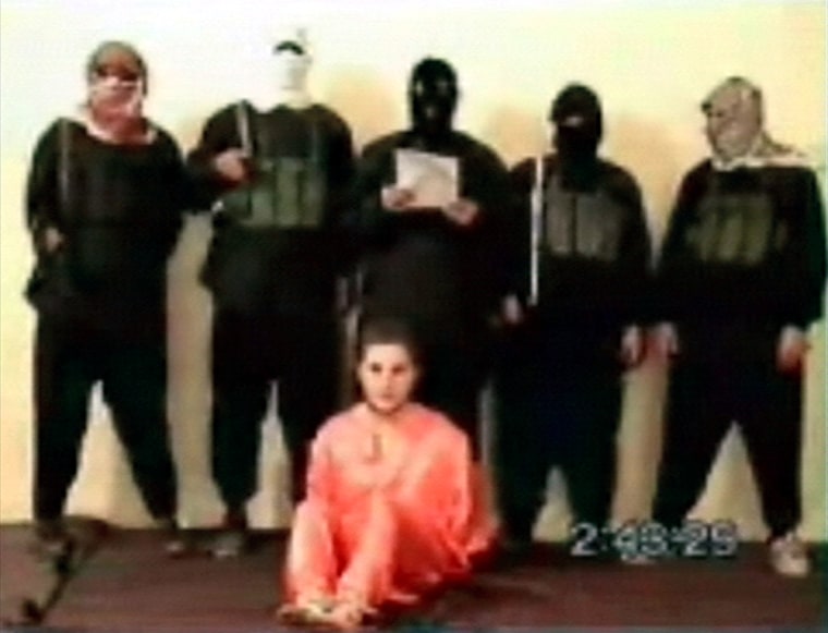 This is a image made from a video posted Tuesday May 11, 2004 on an Islamic militant Web site affiliated with al-Qaida showing a group of five men wearing headscarves and black ski masks standing over a bound man in an orange jumpsuit, who identified himself as Nick Berg, a U.S contractor whose body was found on a highway overpass in Baghdad on Saturday. (AP Photo via APTN)  ** TV OUT **