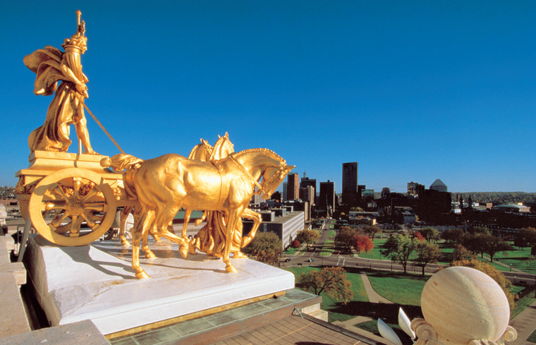 Minnesota State Capital: Gold Chariot 

This gold-leafed copper and steel statuary group, \"Progress of the State,\" sits atop the Minnesota State Capital in St. Paul. Sculpted by Daniel Chester French and Edward Potter, the four horses represent the power of nature: earth, wind, fire and water.
