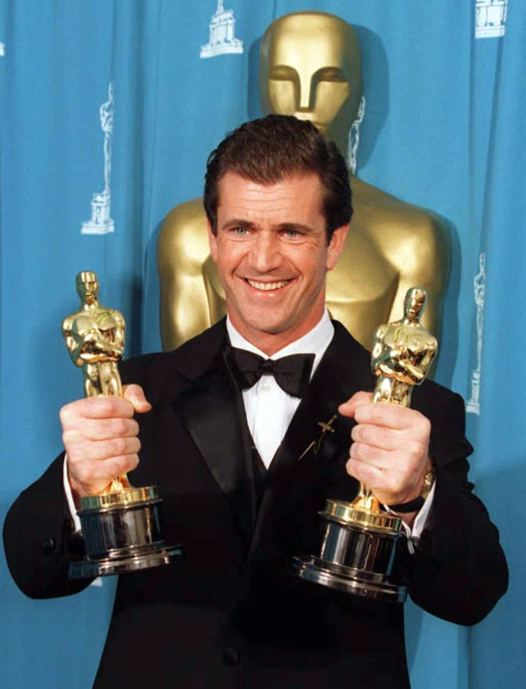 Mel Gibson holds Oscars for Best Director and Best