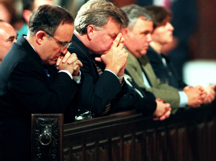 New York Mayor Rudolph Giuliani (L) prays during a