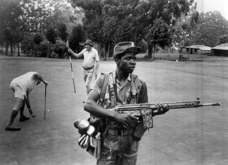 At the Leopard Rock Hotel, in Rhodesia, Dec. 15, 1978, an armed guard provides both service and security on the golf course. (AP Photo/Eddie Adams)