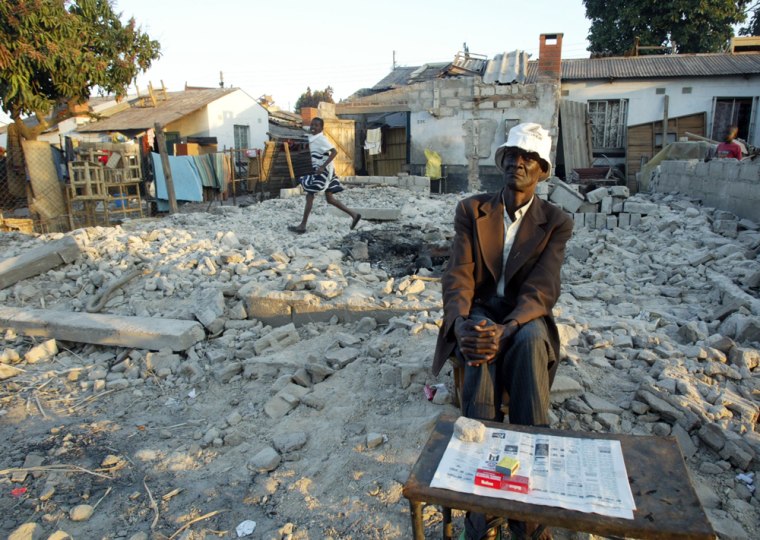 Gerald  Mbizo, left , sits in the rubble of his demolished house in Harare, Monday June 13, 2005. Zimbabwean police are under orders to destroy '' illegal dwellings\" and vendors  shacks as part of  a campaign to clean up the city.  Zimbabwean doctors condemned a government campaign to clear shacks from the cities, saying as many as 1 million people might have been made homeless and expressing particular concern about AIDS victims among those affected. (AP PHOTO/STR)