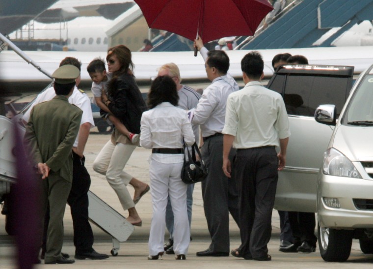 U.S. actress Jolie carries her newly adopted son as she walks from the car to the plane at Noi Bai airport in Hanoi