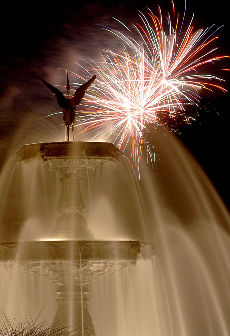 Fireworks being shot off in Town Park in Bloomsburg, Pa., are seen exploding in the sky in the background as the town's fountain flows in the foreground Wednesday, July 4, 2007. (AP Photo/Bloomsburg Press Enterprise, Jimmy May)
