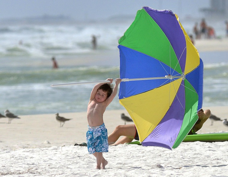 Image: A boy struggles with an umbrella as Tropical Storm Karen approaches the Gulf Coast.