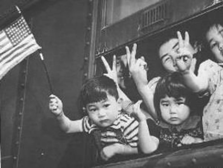 A group of Bainbridge Island Japanese residents wave from a train as they're transferred from Seattle to Owens Valley Reception Center, California, in March of 1942.