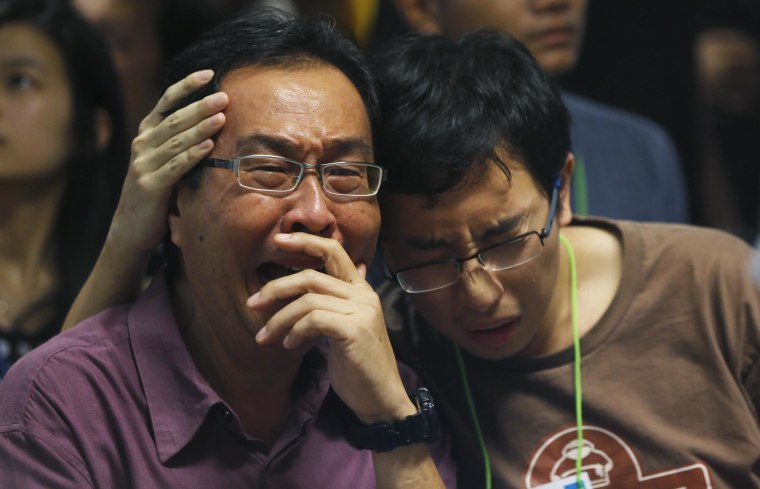 Image: Family members of passengers onboard missing AirAsia flight QZ8501 cry at a waiting area in Juanda International Airport