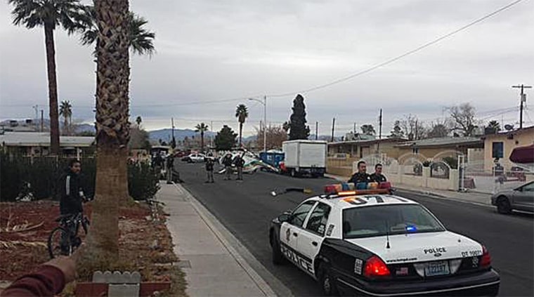 Police respond at the scene of a crashed helicopter on a Las Vegas street.