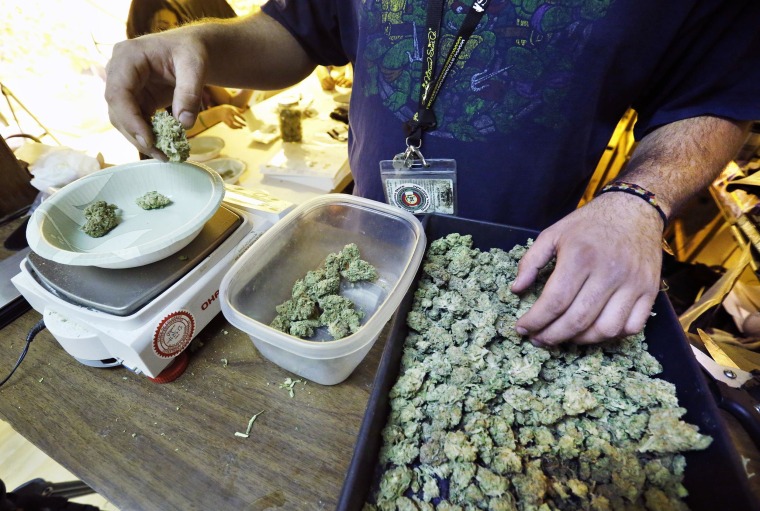 Image: An employee weighs portions of retail marijuana to be packaged and sold at 3D Cannabis Center in Denver.