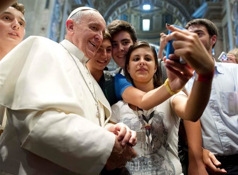 Pope Francis poses with youths during a meeting with the Piacenza diocese in Saint Peter's Basilica at the Vatican in this August 28, 2013 picture provided by Osservatore Romano.