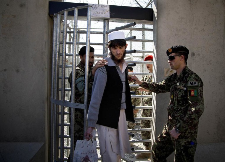 Image: An Afghan prisoner leaves with his belongings from the Parwan Detention Facility.