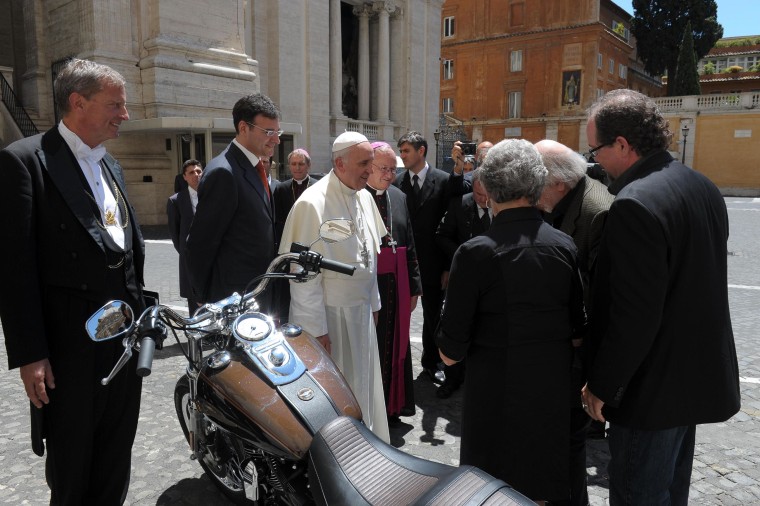 Image: Pope Francis stands by a Harley-Davidson that was donated to him.