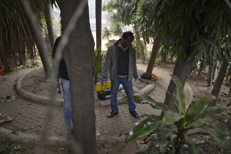 Image: A forensic official examines a spot where a Danish woman alleged she was robbed and gang-raped in New Delhi