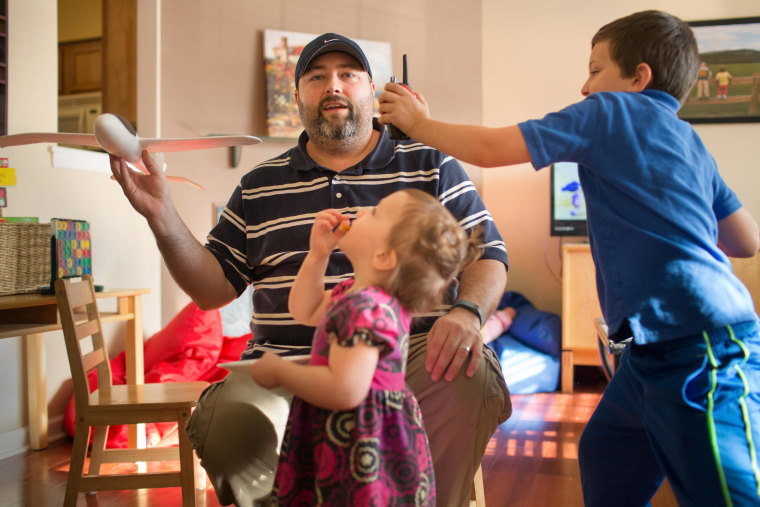 Image: Brad Chaffee plays with his children at home in Charlottesville, Va.