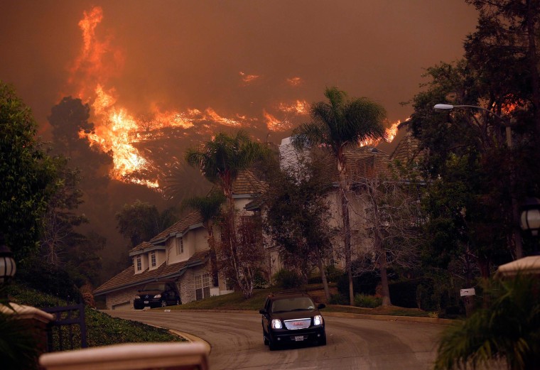 Image: A car drives away from the Colby Fire in hills above Glendora, Calif.