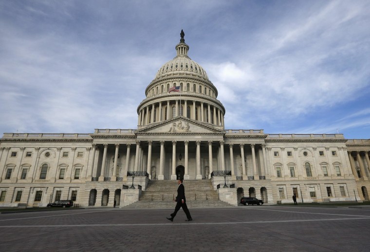 Image: A lone worker passes by the U.S. Capitol building in Washington