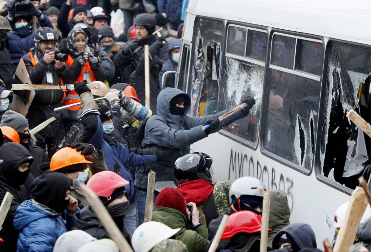 Image: Pro-European protesters attack a police van during a rally near government administration buildings in Kiev