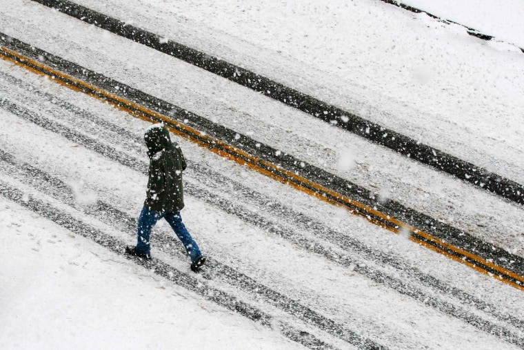 Image: A pedestrian walks through the falling snow in Medford