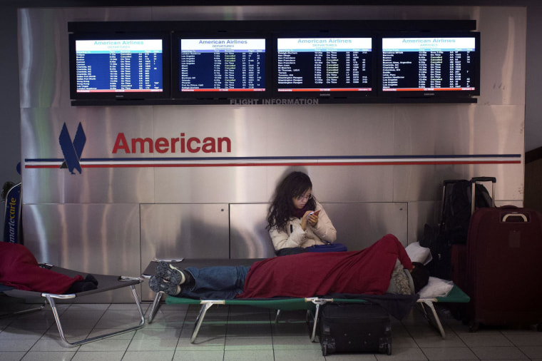 Image: A woman sits on her cot at John F. Kennedy International Airport in New York